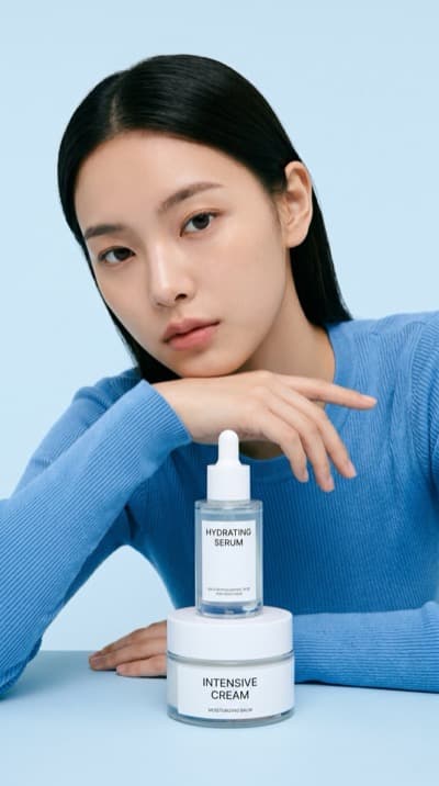 Modelo com Sérum e Creme em Estúdio Azul