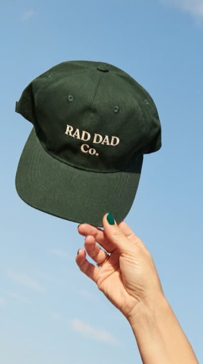 Boné Dad Verde na Mão contra o Céu