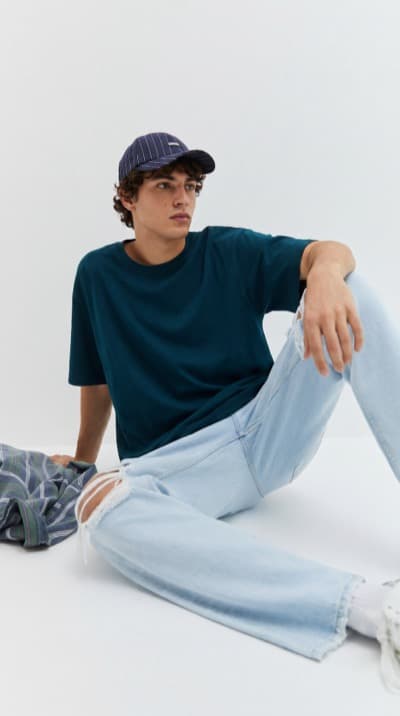 Boné e T-Shirt Sentado em Estúdio Branco